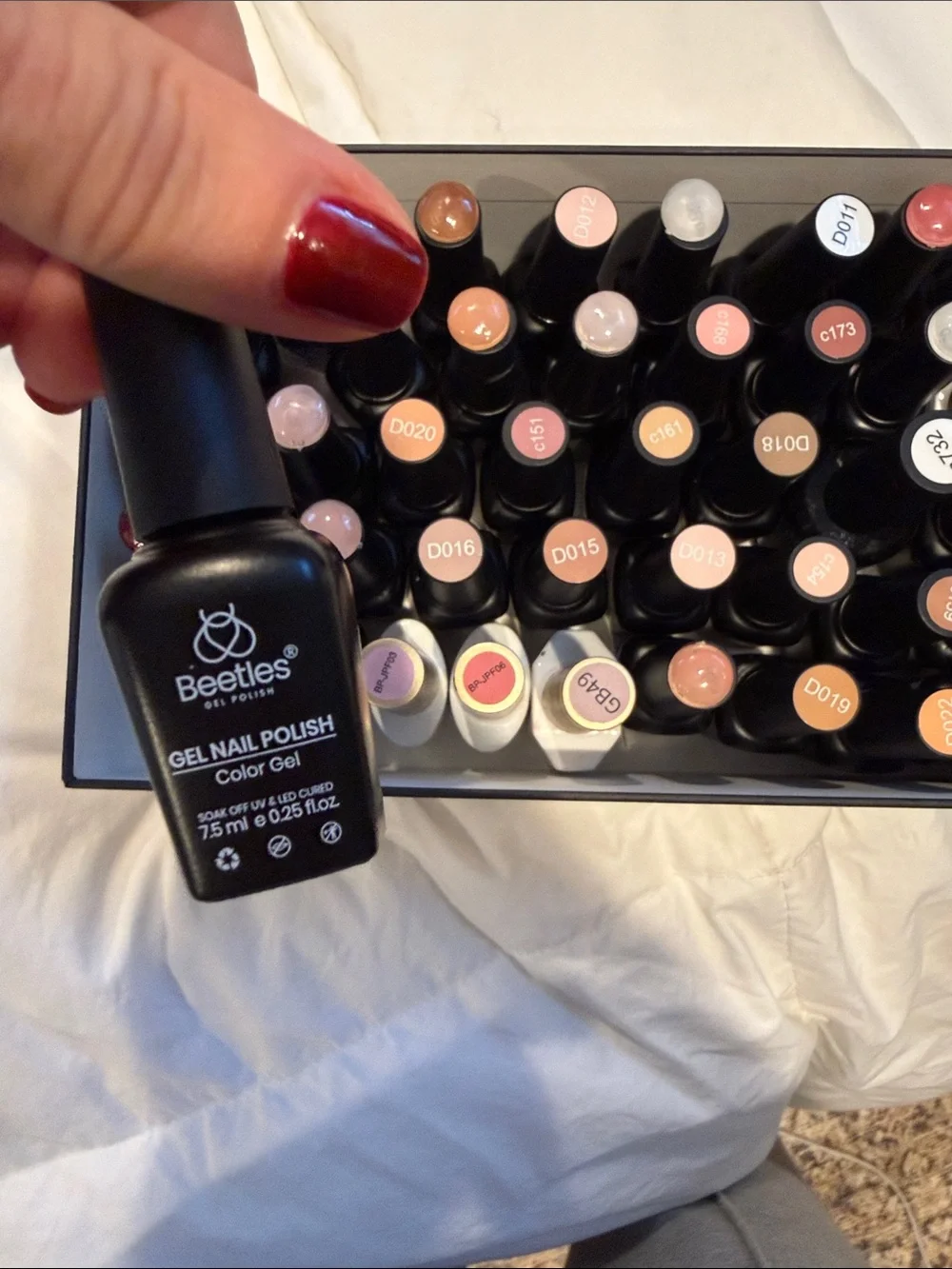 Collection of gel, nail polishes. Mostly light neutrals and dark neutrals.